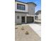 Modern two-story home featuring a light gray exterior, dark trim, and a gravel yard at 7450 S 75Th Dr, Laveen, AZ 85339