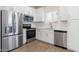 Modern kitchen with stainless steel appliances, white cabinets and hardwood floors at 7450 S 75Th Dr, Laveen, AZ 85339