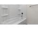 White shower tub with shelving and updated hardware, creating a serene and clean bathroom experience at 7450 S 75Th Dr, Laveen, AZ 85339