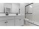 Elegant bathroom with double vanity, black hardware, and a glass-enclosed shower at 23411 W Albeniz Pl, Buckeye, AZ 85326