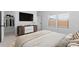 Cozy bedroom featuring a sleek dresser with mounted TV and natural light from nearby windows at 23411 W Albeniz Pl, Buckeye, AZ 85326