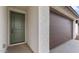 Close up of front door with an olive green finish next to a dark brown garage door at 23411 W Albeniz Pl, Buckeye, AZ 85326