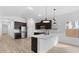 Well-lit kitchen boasting a modern island, stainless steel appliances, and dark cabinets at 23411 W Albeniz Pl, Buckeye, AZ 85326