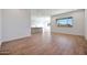 Bright living room featuring wood-look tile floors, white walls, and a view into the modern kitchen at 28233 N 134Th Ave Ave, Peoria, AZ 85383