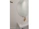 Close up of a bathroom featuring a wall-mounted sink and an oval mirror with gold hardware at 34505 N Timberlake N Mnr, San Tan Valley, AZ 85144