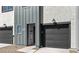Gray townhome with a dark garage door and a well-lit doorway at 7504 S 75Th Dr, Laveen, AZ 85339