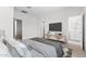 Comfortable main bedroom featuring soft bedding, mounted TV, and ensuite bathroom, creating a serene retreat at 7504 S 75Th Dr, Laveen, AZ 85339
