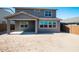 Exterior back view of a modern house, showcasing the covered patio and backyard with fresh landscaping potential at 8975 S 168Th Ln, Goodyear, AZ 85338