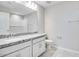 Bathroom features granite countertop with double sinks, white cabinets, tiled flooring, and a shower with tile surround at 8975 S 168Th Ln, Goodyear, AZ 85338