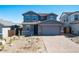 Two-story home featuring blue facade, gabled roof, with a brick driveway leading to an attached two-car garage at 8975 S 168Th Ln, Goodyear, AZ 85338