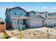 Two-story home featuring blue facade, gabled roof, with a brick driveway leading to an attached two-car garage at 8975 S 168Th Ln, Goodyear, AZ 85338