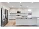 Bright kitchen with stainless steel appliances, an island with bar seating, and white cabinetry at 8975 S 168Th Ln, Goodyear, AZ 85338