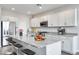 A modern kitchen features stainless appliances, granite counters, and a large island with bar seating at 8975 S 168Th Ln, Goodyear, AZ 85338