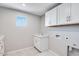 Clean, efficient laundry room featuring a sink, storage cabinets, and washer/dryer hookups at 8975 S 168Th Ln, Goodyear, AZ 85338
