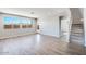 Bright living room with large windows offering natural light and views, plus modern wood-look flooring and staircase at 8975 S 168Th Ln, Goodyear, AZ 85338
