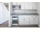 Mini-bar with white cabinetry, granite countertops, a built-in wine cooler, and stainless steel appliances at 8975 S 168Th Ln, Goodyear, AZ 85338