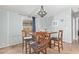 This is a dining area with a modern chandelier, wooden table, seating for four, and gray walls at 10120 E Mclellan Rd, Mesa, AZ 85207