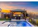 Outdoor kitchen and dining area under a covered pergola, adjacent to the pool at 34801 N 53Rd St # 26, Cave Creek, AZ 85331