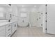 Elegant bathroom with soaking tub, walk-in shower, and patterned tile at 37767 W Padilla St, Maricopa, AZ 85138