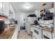 Galley-style kitchen with white cabinets and appliances at 4625 E Southgate Ave, Phoenix, AZ 85040