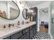 Modern bathroom with dark vanity, double sinks, and a checkerboard floor at 6319 E Mariposa St, Scottsdale, AZ 85251