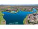 Aerial view of a community showcasing a large lake and surrounding homes with mountain views in the distance at 17915 W Silver Fox Way, Goodyear, AZ 85338