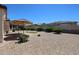 Expansive backyard features low-maintenance landscaping and a shaded patio area, perfect for outdoor entertaining at 17915 W Silver Fox Way, Goodyear, AZ 85338