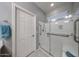 Walk-in shower features glass doors, grab bars and a seat for accessibility at 17915 W Silver Fox Way, Goodyear, AZ 85338