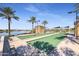 Well-maintained bocce ball court alongside a lake and lush desert landscaping at 17915 W Silver Fox Way, Goodyear, AZ 85338