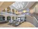 Grand clubhouse interior with soaring ceilings, elegant seating areas, and a staircase leading to upper levels at 17915 W Silver Fox Way, Goodyear, AZ 85338
