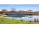 Welcome to Cantamia: A serene community entrance framed by lush landscaping and a tranquil pond reflecting the sky at 17915 W Silver Fox Way, Goodyear, AZ 85338