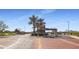 Inviting community entrance with brick-paved road, palm trees, and neatly manicured landscaping, setting an upscale tone at 17915 W Silver Fox Way, Goodyear, AZ 85338