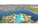 Aerial view of a resort-style community pool surrounded by palm trees and manicured grounds near the lake at 17915 W Silver Fox Way, Goodyear, AZ 85338