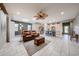 Spacious living area with tile floors, a ceiling fan, and open access to the kitchen and dining space at 17915 W Silver Fox Way, Goodyear, AZ 85338