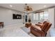 Comfortable living room with a ceiling fan, entertainment center, and easy flow to the kitchen and dining area at 17915 W Silver Fox Way, Goodyear, AZ 85338