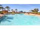 Expansive community pool featuring clear blue water and lush palm trees at 17915 W Silver Fox Way, Goodyear, AZ 85338