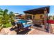 Backyard oasis featuring a sparkling pool, patio seating under pergola, and beautiful desert plants at 18174 W Wind Song Ave, Goodyear, AZ 85338