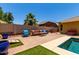 Well-maintained backyard with a patio, lounge seating, and a partial view of the refreshing pool at 18174 W Wind Song Ave, Goodyear, AZ 85338