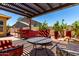 Backyard setting with outdoor kitchen, lounge area under pergola, and beautiful desert landscaping at 18174 W Wind Song Ave, Goodyear, AZ 85338