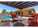 Cozy backyard featuring a pool, patio seating under pergola, and views of the home's exterior at 18174 W Wind Song Ave, Goodyear, AZ 85338