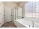 Bright bathroom with a separate shower and soaking tub with natural light at 18174 W Wind Song Ave, Goodyear, AZ 85338