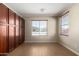 Spacious bedroom with wood floors, plenty of storage space, and two large windows at 18174 W Wind Song Ave, Goodyear, AZ 85338