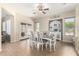 Spacious dining room featuring hardwood floors, a ceiling fan, and a large table perfect for Gathering gatherings at 18174 W Wind Song Ave, Goodyear, AZ 85338