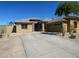 Beautiful tan single-story home with a spacious driveway, desert landscaping, and a 2-car garage at 18174 W Wind Song Ave, Goodyear, AZ 85338