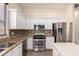 Close-up shot of kitchen appliances, granite countertops, white cabinets, and a mosaic backsplash for added visual interest at 18174 W Wind Song Ave, Goodyear, AZ 85338