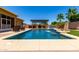 Relaxing pool view with a waterfall feature and shaded pergola seating area for outdoor entertaining at 18174 W Wind Song Ave, Goodyear, AZ 85338