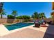 Spacious backyard with a well-maintained pool, comfortable lounge seating, and outdoor fire pit at 18174 W Wind Song Ave, Goodyear, AZ 85338