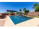 Inviting backyard pool with blue tiling, a waterfall feature, and a shaded pergola seating area at 18174 W Wind Song Ave, Goodyear, AZ 85338
