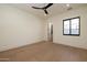 Minimal bedroom featuring hardwood floors, a ceiling fan, and a walk-in closet at 23002 N Country Club Trl Trl, Scottsdale, AZ 85255