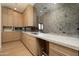 Bright prep kitchen with ample wooden cabinets, marble countertops, and mirrored backsplash at 23002 N Country Club Trl Trl, Scottsdale, AZ 85255